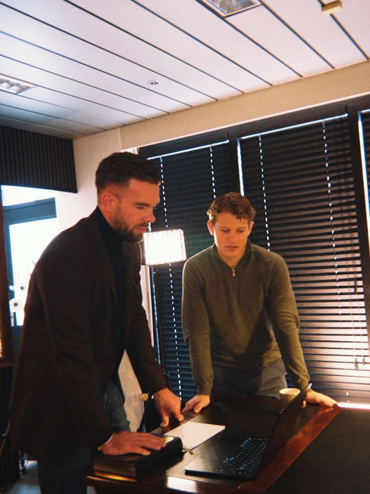 Aan het bureau bij een klant, samen over de laptop gebogen