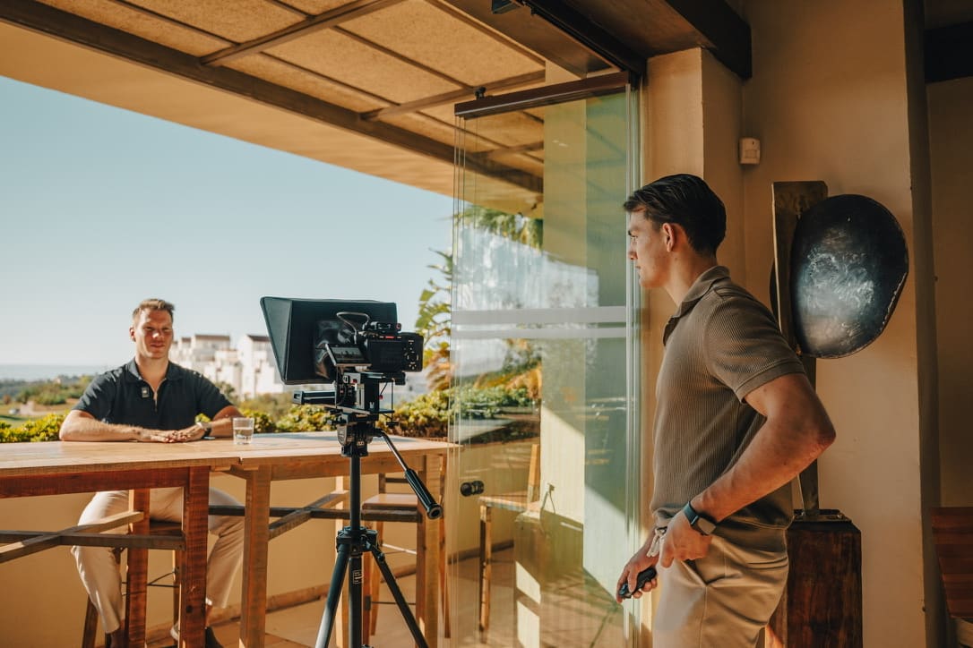 Interview op een terras met uitzicht, teleprompter voor de camera en de regisseur ernaast